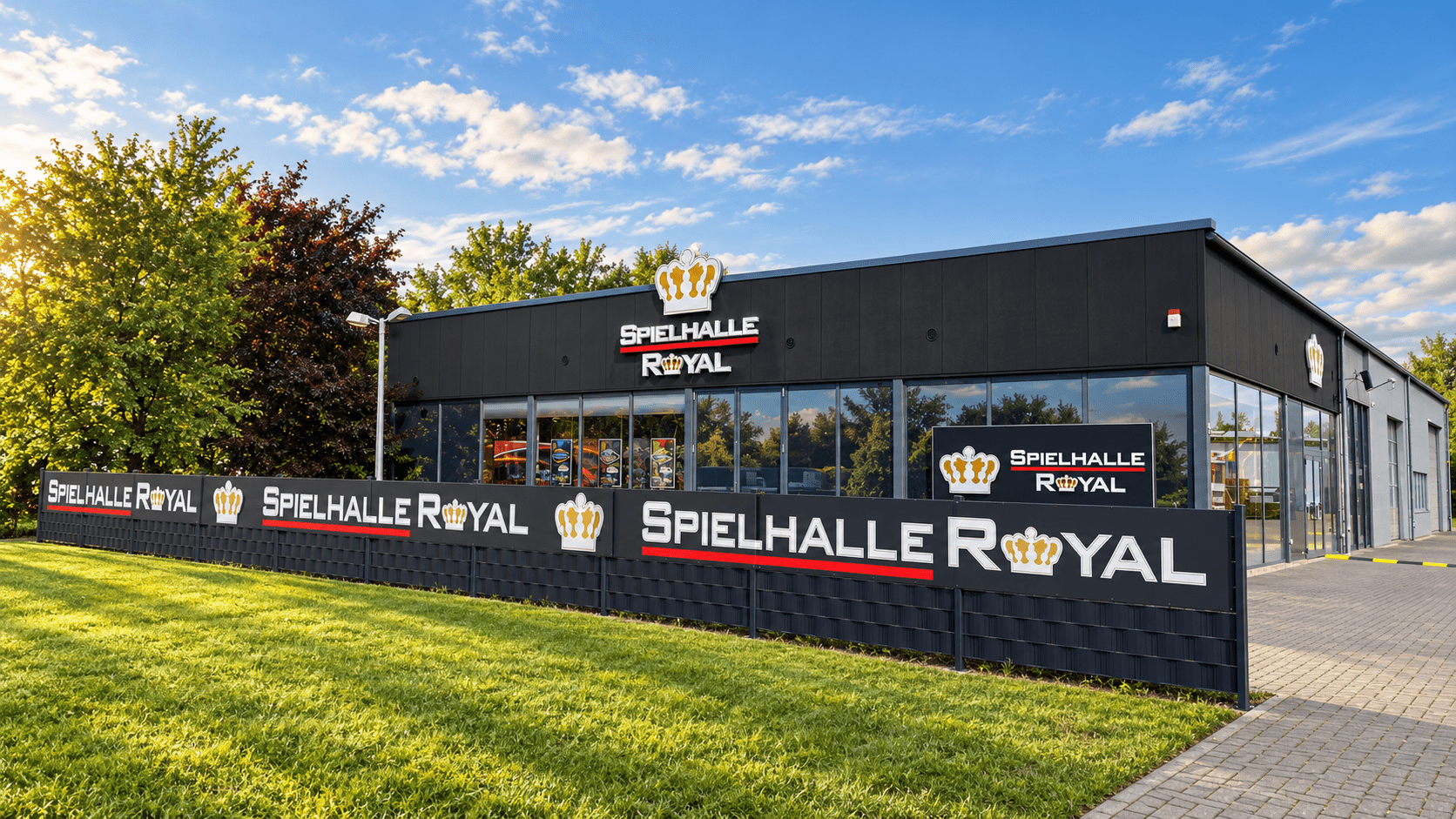 Royal Spielhalle mit anthrazitfarbener Fassade, Royal Kronen und gepflegter Außenanlage