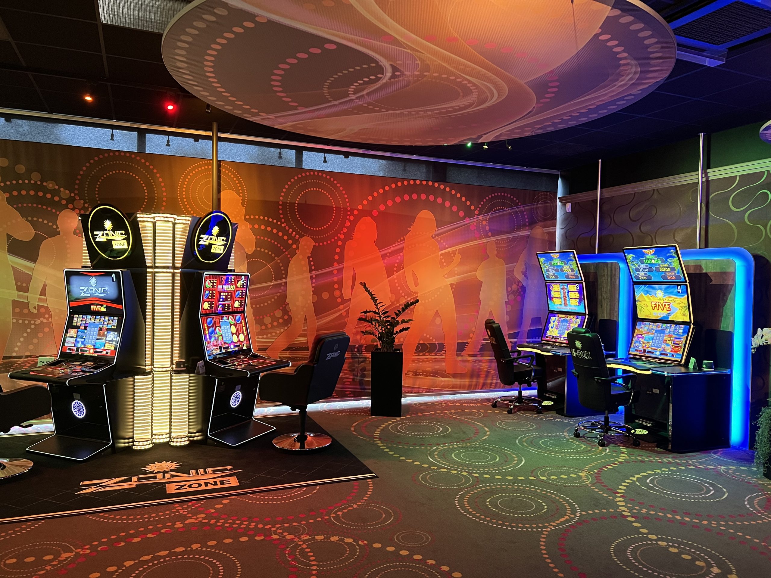 Innenansicht einer Royal Spielstätte mit beleuchteten Spielautomaten und farbiger Raumgestaltung